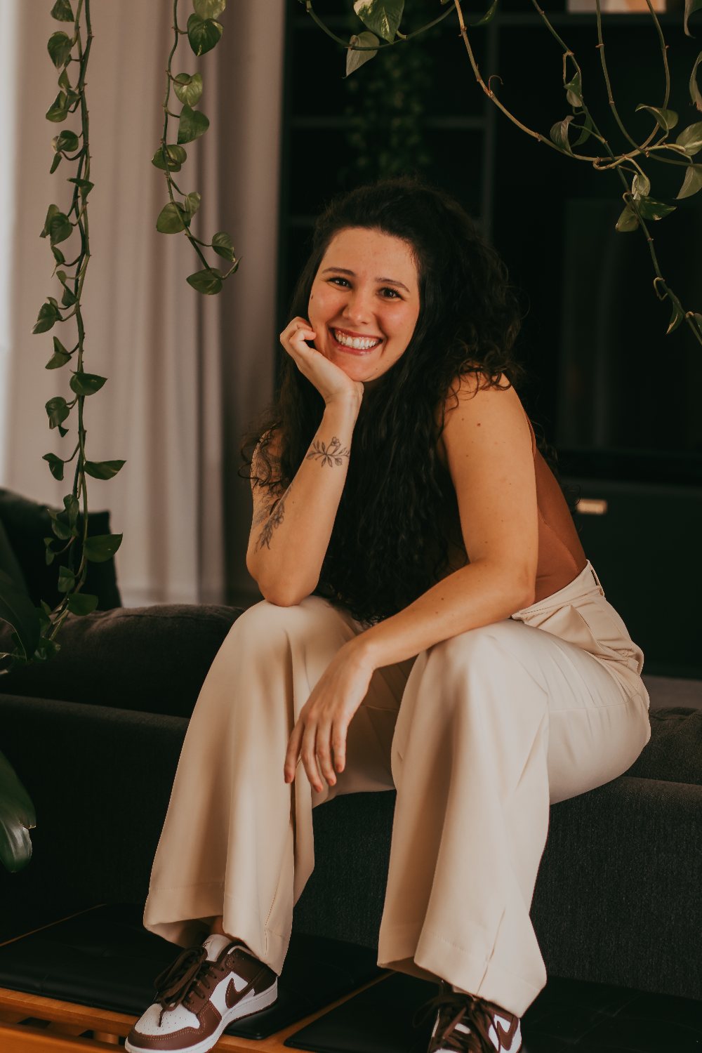 Julia Kalil sorrindo, sentada num sofá